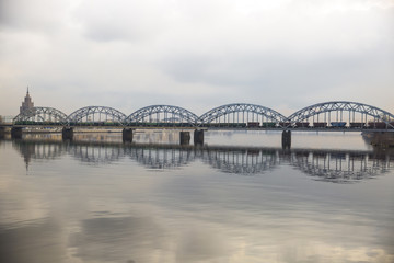 Fototapeta premium Picturesque view over the metal Railway Bridge over the Daugava river in Riga, Latvia