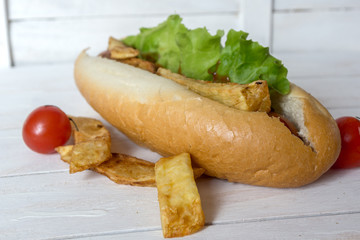 Barbecue Grilled Hot Dog with ketchup, french fries and Cherry tomatoes on wooden background