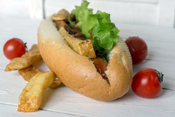 Barbecue Grilled Hot Dog with ketchup, french fries and Cherry tomatoes on wooden background