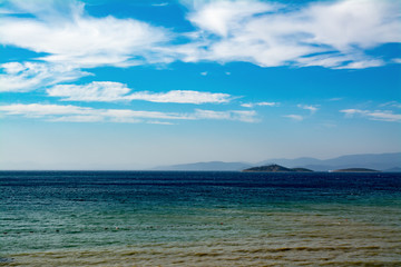 Fototapeta na wymiar cloudy blue sky leaving for horizon above a blue surface of the sea