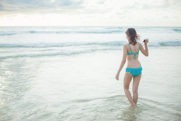 Fototapeta na wymiar a lady walking at the paradise beach horizontal