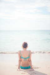 a lady sitting at the paradise beach vertical