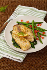 Baked Fish Fillet with Sauteed Spinach. Selective focus.