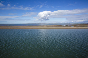 Obraz premium maritime seaside landscape with water, sand bank and white cloud, garonne estuary near Royan, France