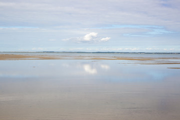 Fototapeta na wymiar maritime seaside landscape with water, sand bank and white cloud, garonne estuary near Royan, France