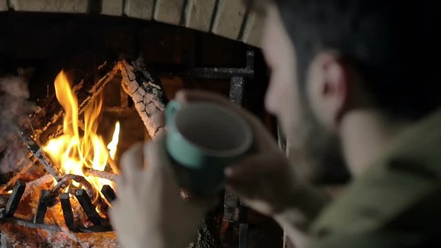 meditative man heat his hands in front of a burning fire