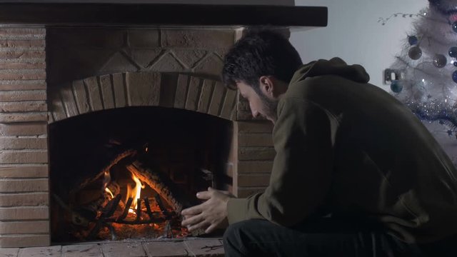 meditative man heat his hands in front of a burning fire