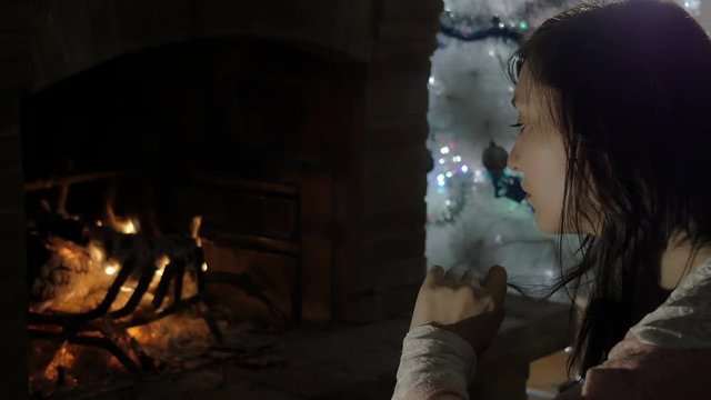 wet young woman sat in front of a fireplace, light, christmas time