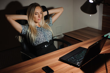 Portrait of stressed businesswoman sitting at office desk and th
