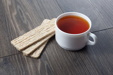 white cup of tea with cookies on a wooden table