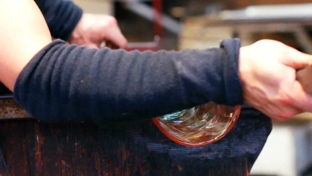Glassblower shaping a molten glass