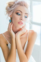 young beautiful blonde woman posing in white Studio. Portrait wi