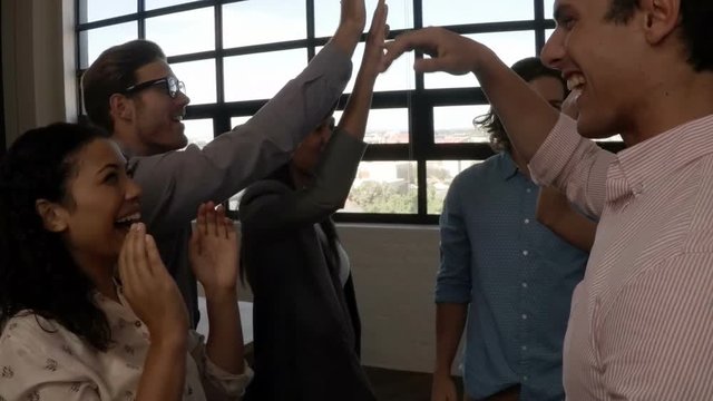 Group of business executives giving high five to each other