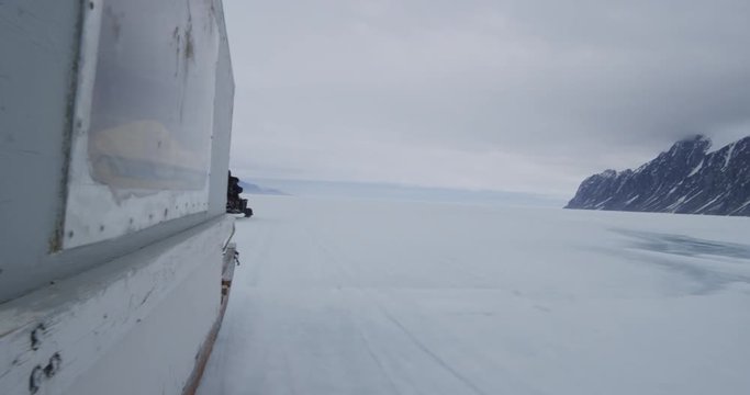 Ice level shot of snow machines in arctic on stormy day