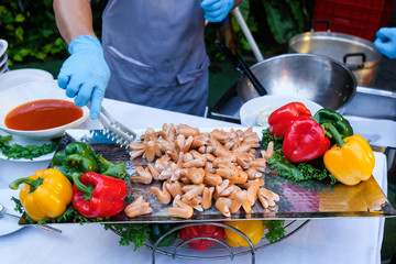 fried sausage on silver tray and hands