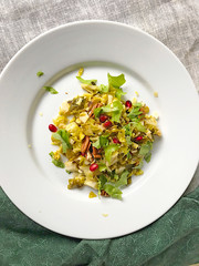 Overhead view of brussels sprouts salad with baby lettuces, pomegranate seeds and pecans