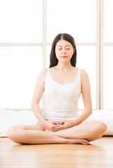 asian woman meditating zen in morning beside bed