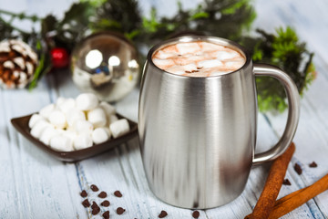 Hot chocolate in stainless steel cup with Christmas decorations