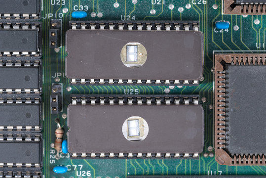 Extreme closeup of two EPROM&acute;s on an old computerboard used in the 1980th.