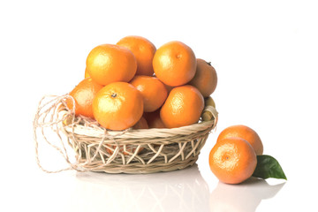 heap of ripe tangerine in a small wicker basket