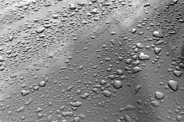 Rain drops on black and white metal surface.