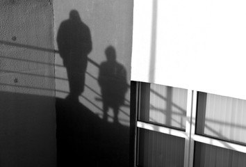 People silhouette on office building wall