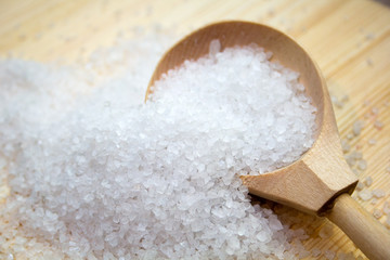 sea salt in wooden spoon on wooden background. Spa concept. cooking concept.
