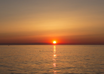Fiery sunrise at Italian beach. Summer season. Emilia Romagna region. Adriatic sea. Italy