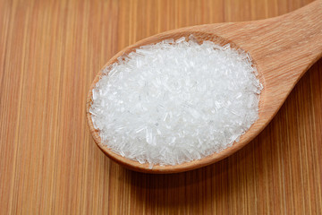 Fototapeta na wymiar mono-sodium glutamate in wooden spoon and on wooden table