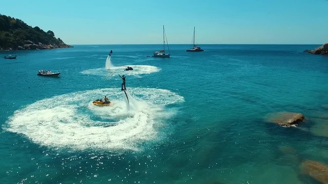 Aerial: Flip on flyboard on the beach.