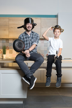 father and kid having great time in kitchen. Father and son havi