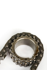 Used oiled timing chain on crang shaft isolated over white backg