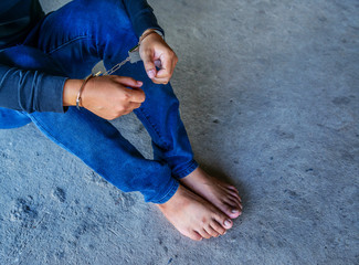 Man sitting on floor and hands locked in handcuffs