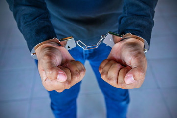 Male hands locked in handcuffs, Outlaw's hands in handcuffs