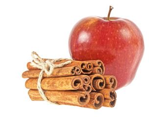 Red apple and cinnamon sticks on a white background