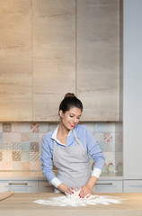 Young woman knead dough at kitchen, homemade bakery making.