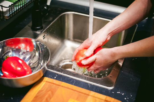 woman washing vegetables for cooking, water under the tap