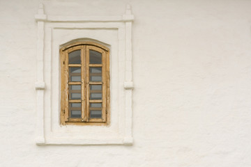 Fototapeta na wymiar Window with wooden frame on a background of white stone wall