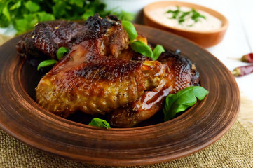 Fried wings (duck, chicken) in a honey glaze in a clay bowl. Close up
