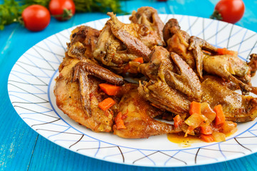 Quail stew with vegetable gravy on a blue wooden table. Close up