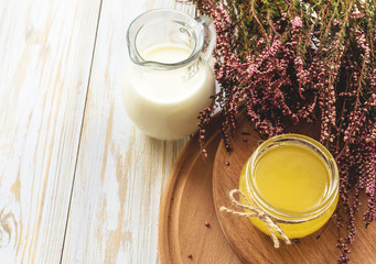 Milk, heather flowers and honey. Wooden table.