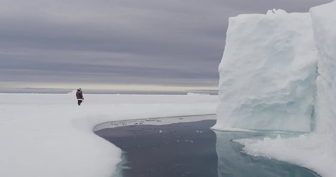 Wide - photographer walking to glacier cliff to take picture