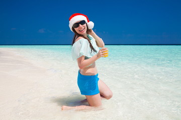 Maldives,  woman Christmas hat, blue shorts and blouse, drinking