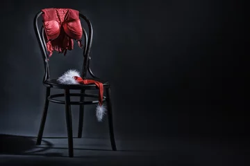Women's underwear and hat of Santa Claus hanging on a retro chair. Erotic Christmas motif. © papa