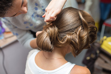 Fototapeta premium evening hairstyle. Blond doing hairdresser and styling in barber salon