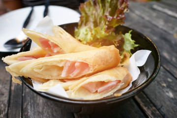 Sliced ham cheese springroll dish for dinner on the wooden table