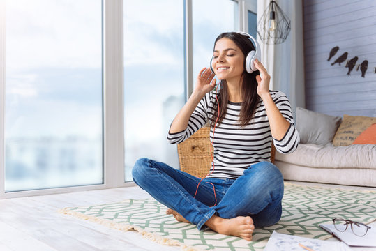 Inspired young woman listening the music at home