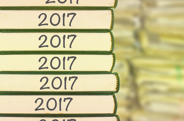 Obraz premium Stack of books and blur background with number year 2017