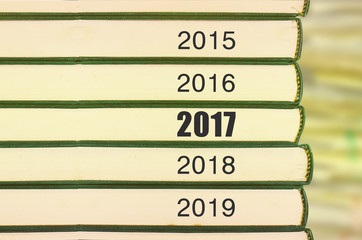 Obraz premium Stack of books and blur background with number year 2017 selected