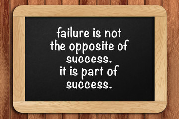 Inspirational motivating quote on chalkboard with wooden background. Failure is not the opposite of success. it is part of success.